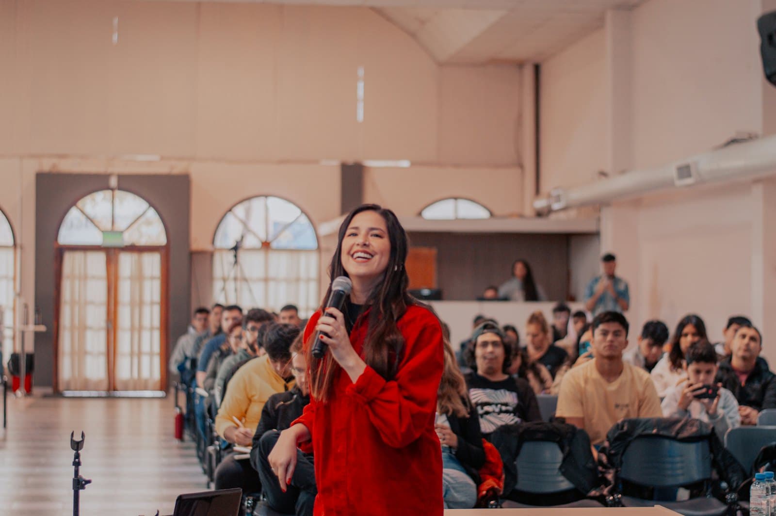 A speaker with a microphone in front of an audience